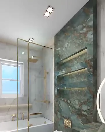 Yeşil mermer duvarlı banyo, altın renkli armatürler, cam duşakabin, küvet ve asma klozet