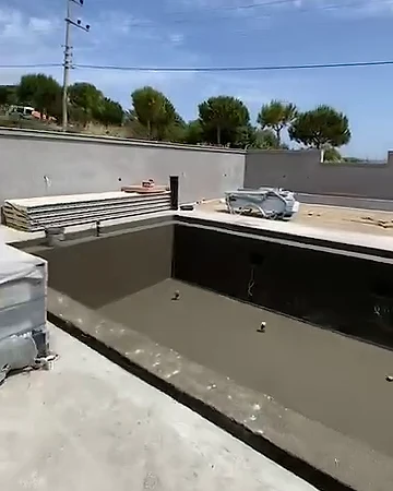 Su yalıtımı yapılmış koyu renkli havuz kabuğu, çevresinde beton zemin